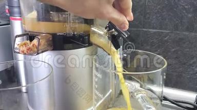 女人`手用苹果汁换水壶。 果汁从榨汁机里倒出来。 4k视频